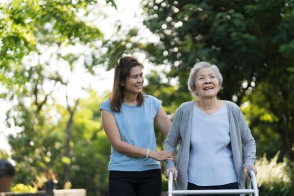 Shot of senior woman  practice to walk with mobility walker with caregiver or  daughter.