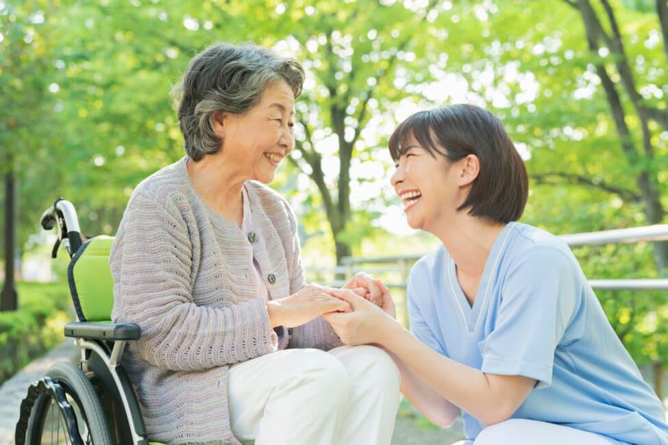 Senior woman in wheelchair and female health care worker.